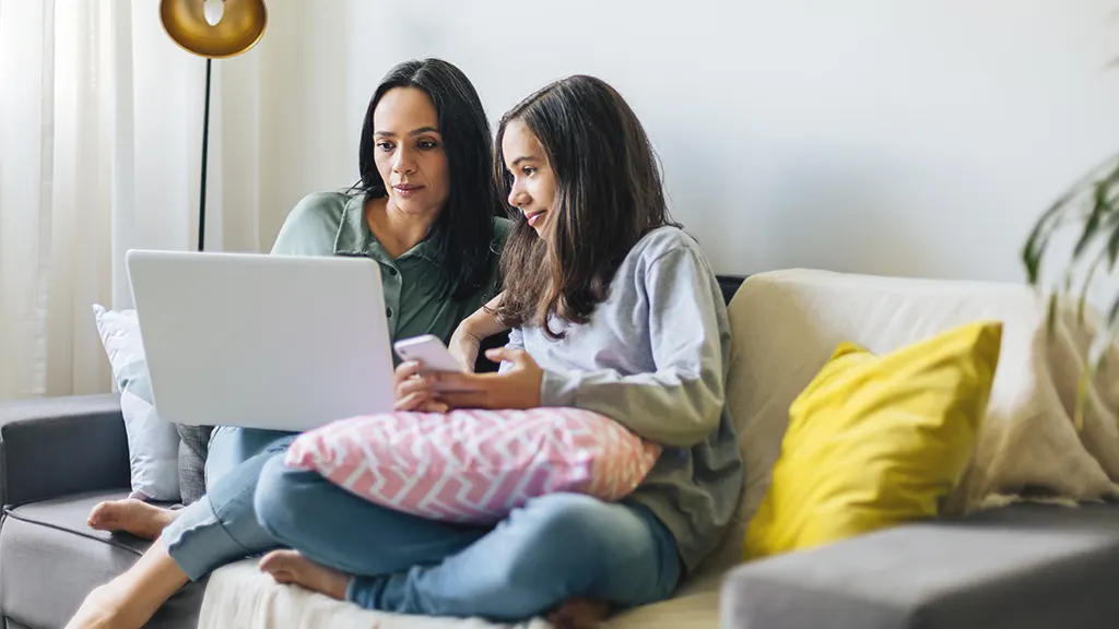 Parent and child looking at online safety tips on computer