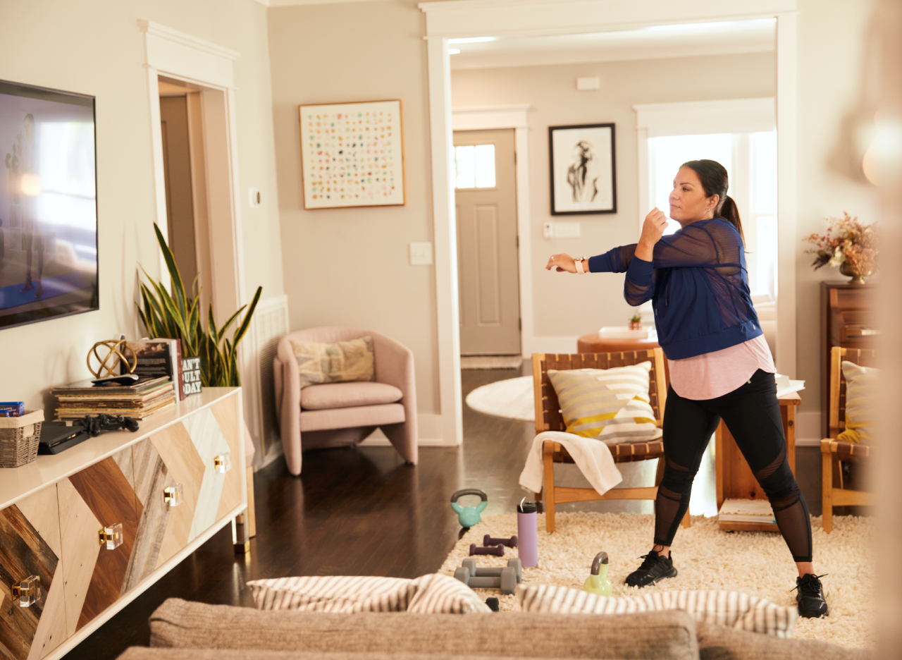 A woman exercising to an app on her television