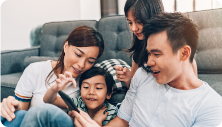 Family on the couch looking at a phone