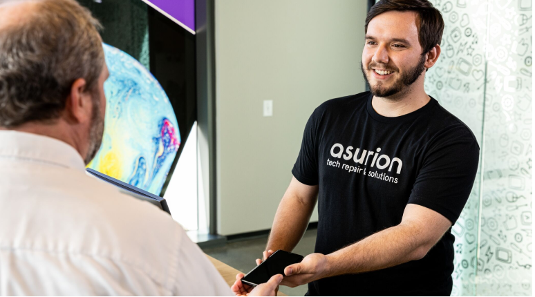 An Asurion expert helping a customer with his phone in-store